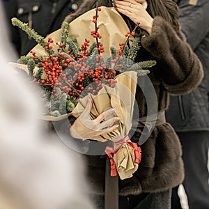 Woman hands holding bouquet of red ilex verticillata, winterberry for Christmas decoration