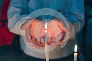 Woman hands holding burning candle