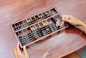 Woman hands holding Chinese ABACUS old antique calculator retro finance education, tool work business accounting
