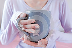 Woman hands holding coffee cup. Girl in sweater holding mug. Morning drink lifestyle.