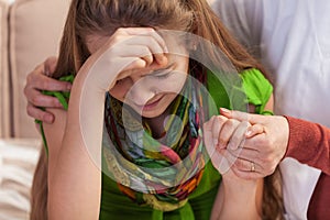 Woman hands holding and consoling crying young girl. Teenage problems concept, close up