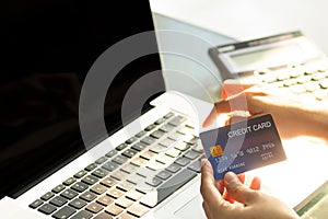 Woman hands holding credit card and using laptop. Online shopping at home. Photo with copy space