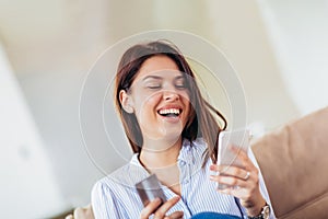 Woman hands holding a credit card and using smart phone for online shopping