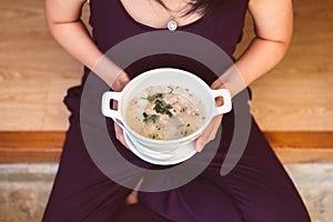 Woman hands holding and eating mush or boiled rice,Healthy breakfast in the morning,Enjoys of resting time,Top view