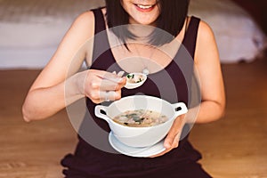 Woman hands holding and eating mush or boiled rice,Healthy breakfast in the morning,Enjoys of resting time