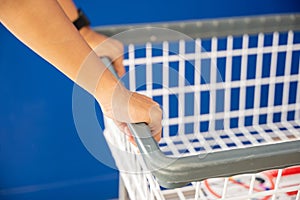 Woman hands holding empty new white trolley cart