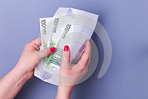 Woman hands holding envelope with cash. Euro banknotes.