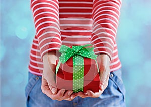 Woman hands holding a gift or present box with bow of green ribbon for Valentines Day