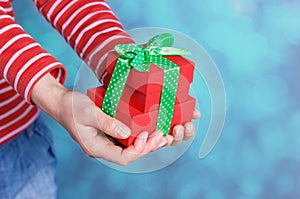 Woman hands holding a gift or present box with bow of green ribbon for Valentines Day