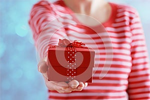 Woman hands holding a gift or present box with bow of red ribbon for Valentines Day