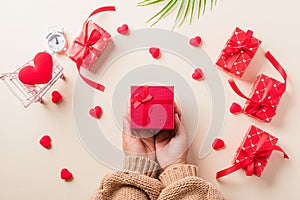 Woman hands holding gift or present box decorated and red heart surprise