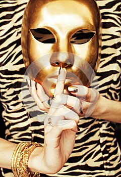 Woman hands holding golden carnival mask, rich