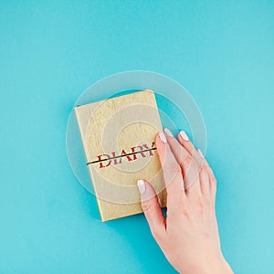 Woman hands holding golden diary