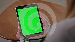 Woman hands holding greenscreen tablet in apartment close up. Girl with mockup