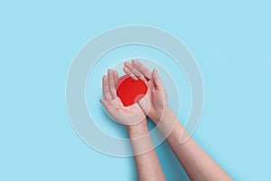 Woman hands holding heart on the blue background. give love philanthropy. donate help warmth and take care. valentines