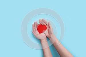 Woman hands holding heart on the blue background. give love philanthropy. donate help warmth and take care. valentines photo
