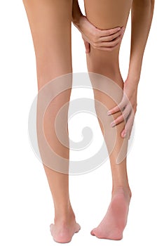 Woman hands holding her beautiful healthy long leg with massaging calf and thigh in pain area.