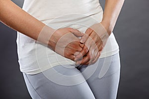 Woman with hands holding her crotch