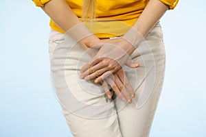 Woman with hands holding her crotch
