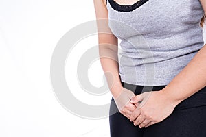 Woman hands holding her crotch suffering from painful stomachache on white background. Medical, healthcare for advertising concept