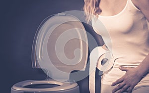 Woman with hands holding her crotch in toilet