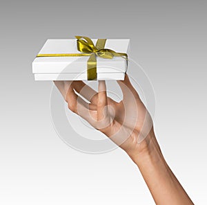 Woman Hands holding Holiday Present White Box with Yellow Golden Ribbon