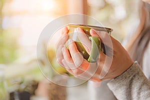 Woman hands holding hot cup of coffee or tea in morning.