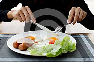 Woman hands holding knife and fork during eating breakfast