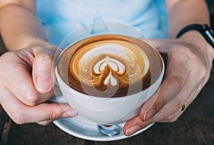 Woman hands holding Latte art coffee