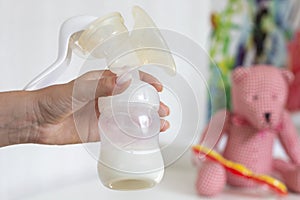 Woman hands holding manual breast pump for expressing milk for feeding baby