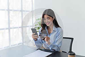 Woman hands holding mock up credit card and mobile phone for shopping online.Pays for purchase.Online shopping concept