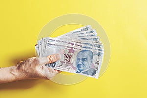 Woman hands holding money on yellow background