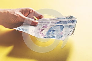 Woman hands holding money on yellow background