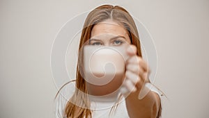 Woman hands holding mug of hot drink. She is smiling and holding a cup of coffee in hand split up in order to inhale the