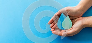 woman hands holding paper cut water drops on a blue background - clean water and sanitation