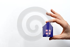 Woman hands holding paper house on white background. Mortgage concept