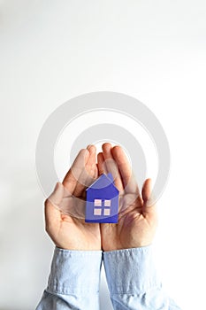 Woman hands holding paper house on white background. Mortgage concept