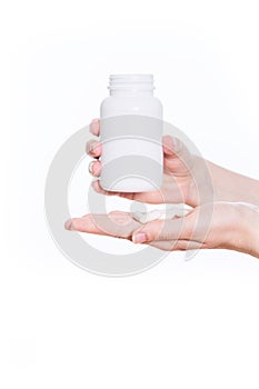 Woman hands holding a pill bottle with pills visible in one hand