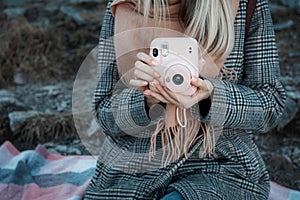 Woman hands holding a pink instax camera