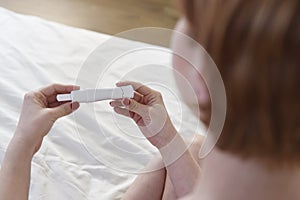 Woman hands holding pregnancy test with blank copy space for positive or negative result composite