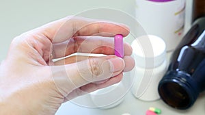 Woman hands holding a purple capsule of Clindamycin, used to treat bacterial infections, or treat patients who have an allergic.