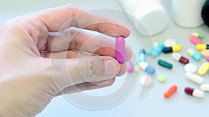 Woman hands holding a purple capsule of Clindamycin, used to treat bacterial infections, or treat patients who have an allergic.