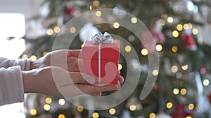 Woman hands holding red gift box presents with silver ribbon bow. Concept Season of giving, Christmas, happy new year