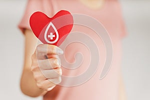 Woman hands holding red heart with blood donor sign. healthcare, medicine and blood donation concept