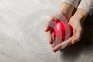 Woman hands holding red heart, health care, love, organ donation, family insurance and CSR concept. World heart day