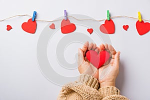 Woman hands holding red heart present decorated surprise