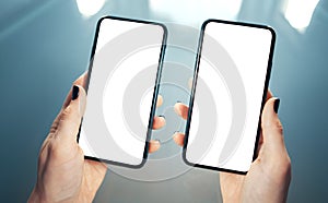 Woman hands holding side by side two smart phones. Comparing, analyzing or matching two products or services - concept. Clean and