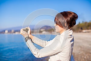 Woman hands holding small stones form heart shape