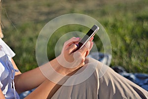 Connected and Relaxed: Woman Enjoying Nature with Smartphone in Hand