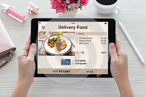 Woman hands holding tablet computer with app delivery food scree